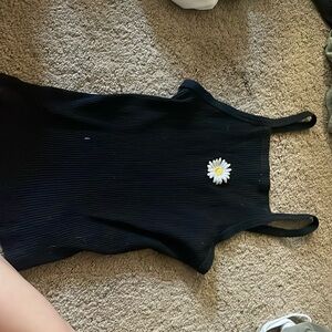 Medium black tank top. Has white and yellow embroidered flower.